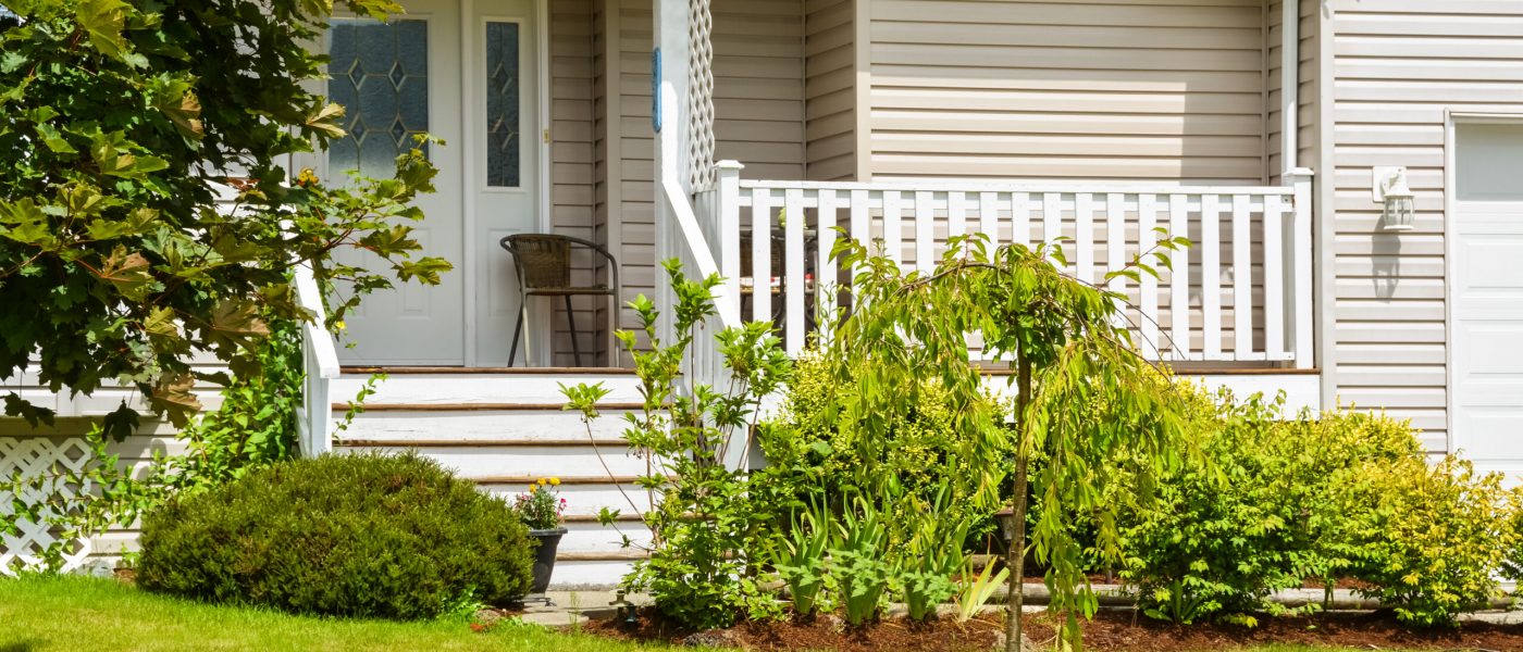 Entrance and porch of residential house with landscaping in front